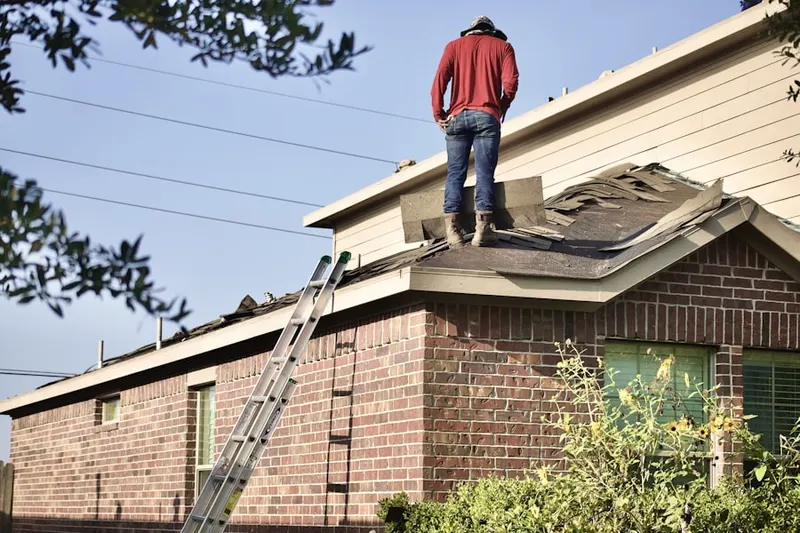 Professional roofer working on a residential roof in South Como